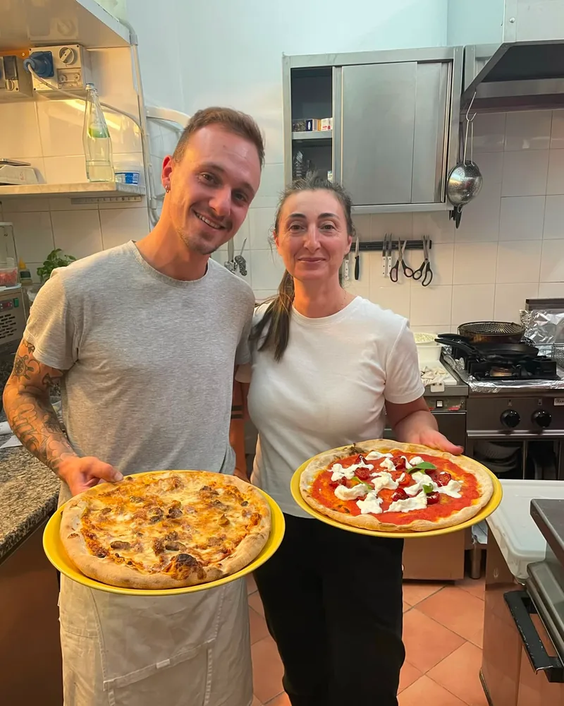 Andrea e Cinzia in cucina con due pizze appena sfornate